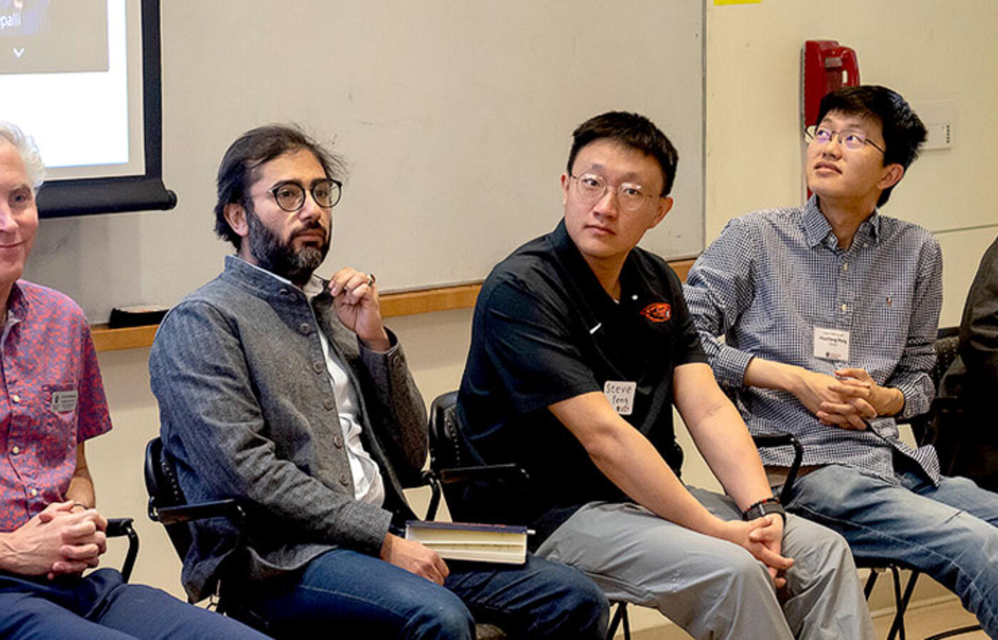 Chris Hundhausen, Houssam Abbas, Zixuan Feng, Huazheng Wang, and David Zier sitting with a presentation behind them.