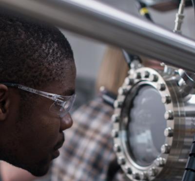 A picture of Kingsley Chukwu looking at a piece of machinery.