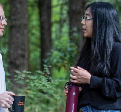 Cory Simon and Xiaoli Fern talking between some trees.