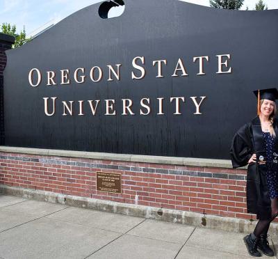 Brittany Blanksma-Stark posing next to a sign that reads "Oregon State University".