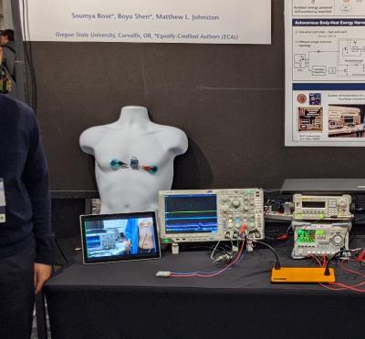 Soumya Bose standing next to his research presentation board.