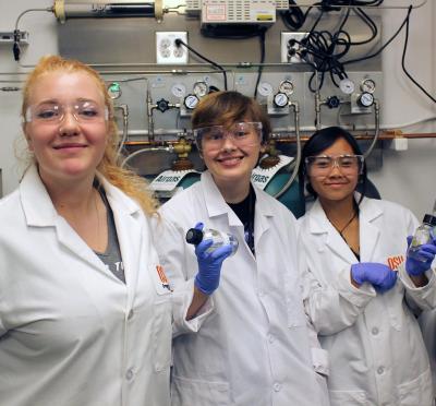 Three students in lab uniform.