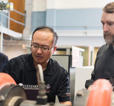 Three engineers working on machine