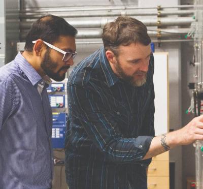 Two people looking at a power generator.