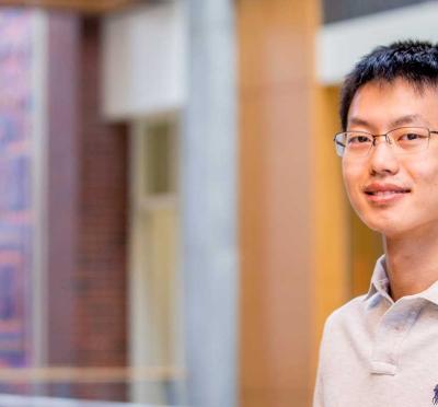 Huazheng Wang, an assistant professor of computer science and AI, stands inside the Kelley engineering building