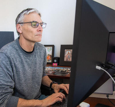 A person working in front of a computer monitor.