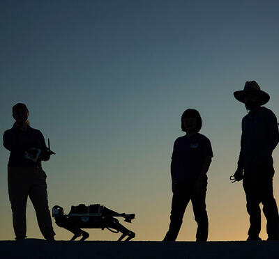 Researchers standing next to a robot.