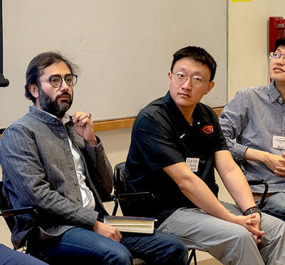 Chris Hundhausen, Houssam Abbas, Zixuan Feng, Huazheng Wang, and David Zier sitting with a presentation behind them.