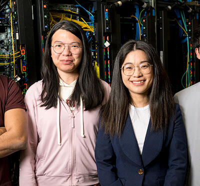 Arunavo Dey, Xulu Chu, Wenqian Dong, and Changqing Li pose in front of a rack of computer servers.