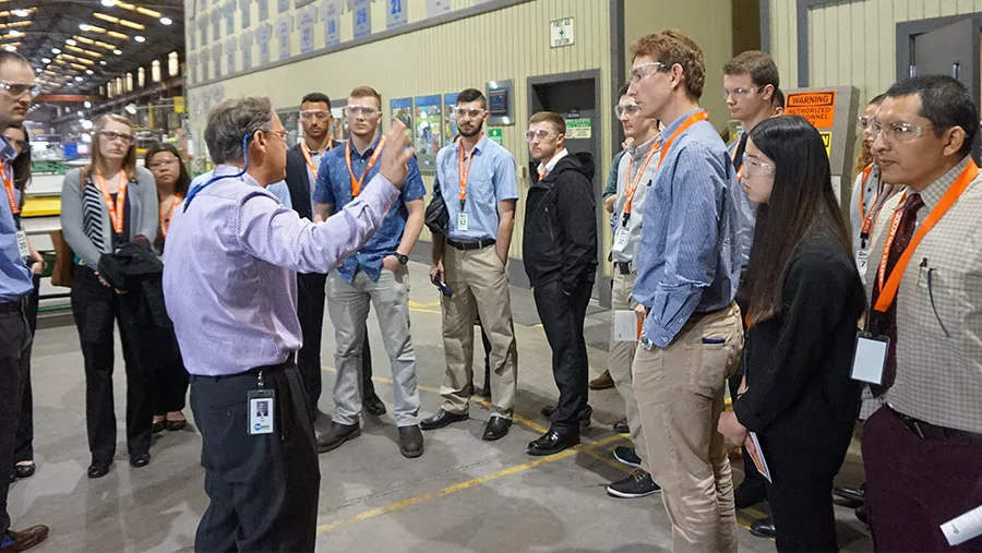 Spokesperson speaking to a crowd of staff members.