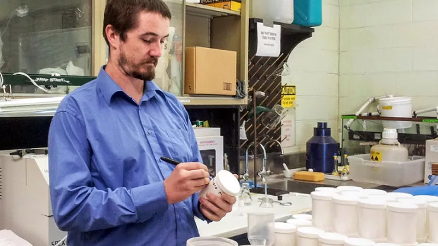 Delvan Neville labeling a lab container. 