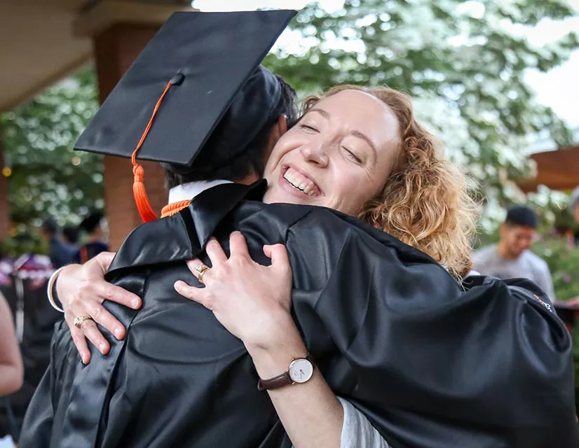 Student and parent hugging at graduation celebration