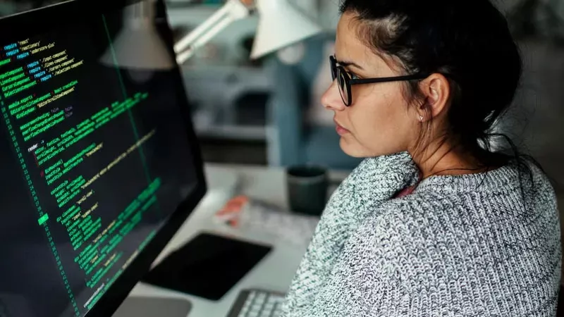 Someone looking at a computer screen of code.