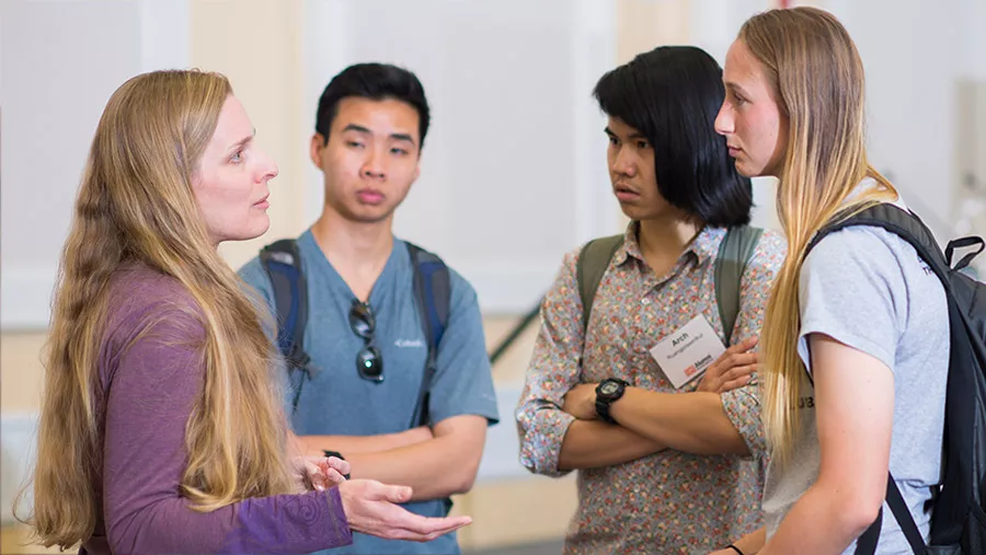 Advisor speaking to three students