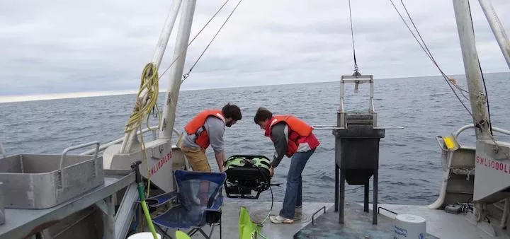 Students deploying a robot at sea.
