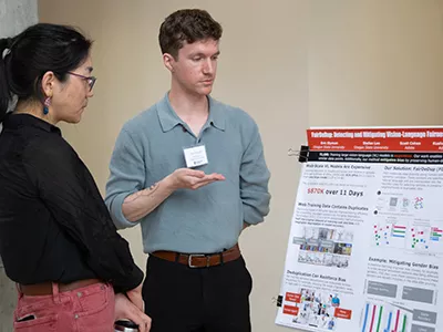 Eric Slyman shows a poster about his research