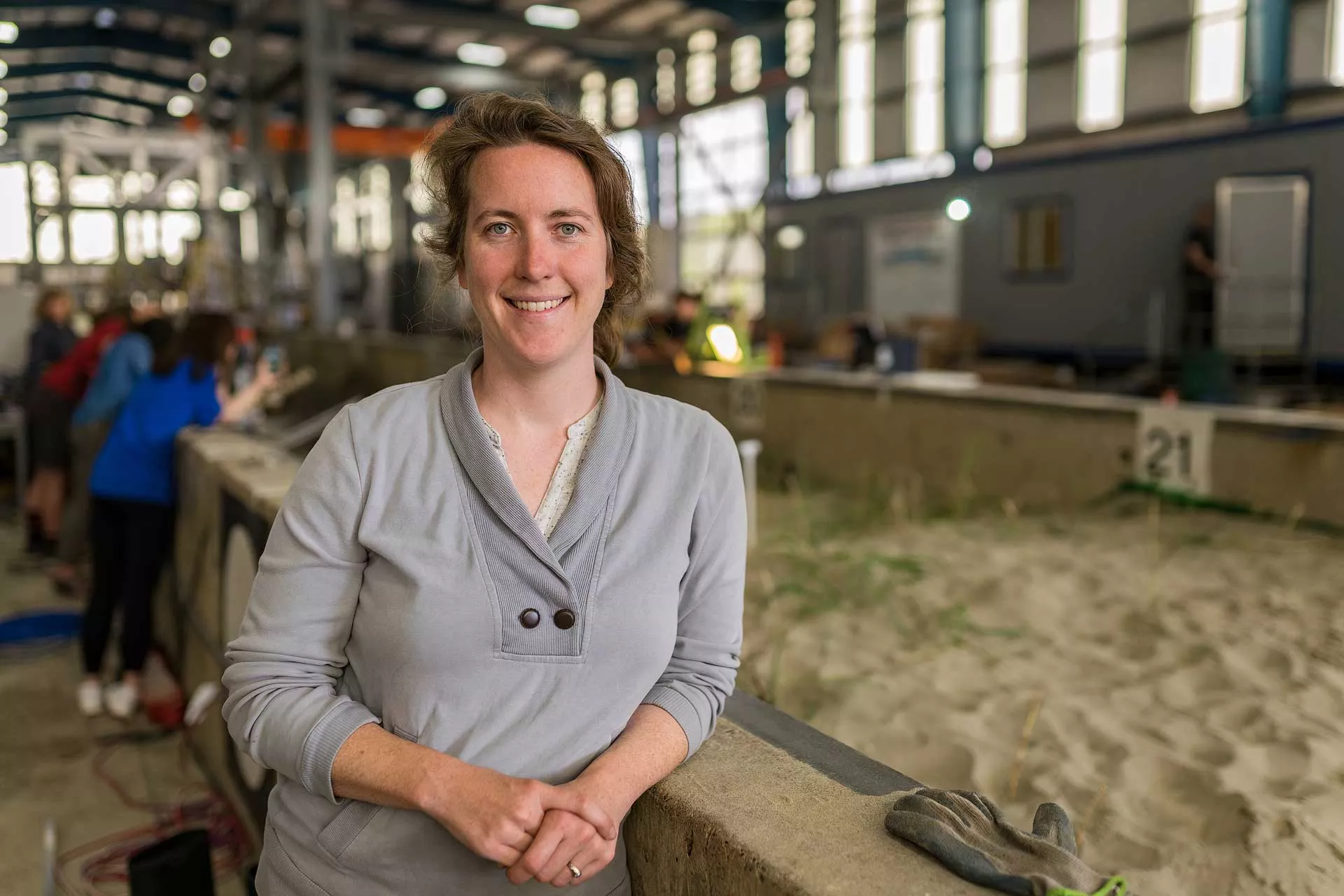 A faculty member standing next to an indoor flume with water. 