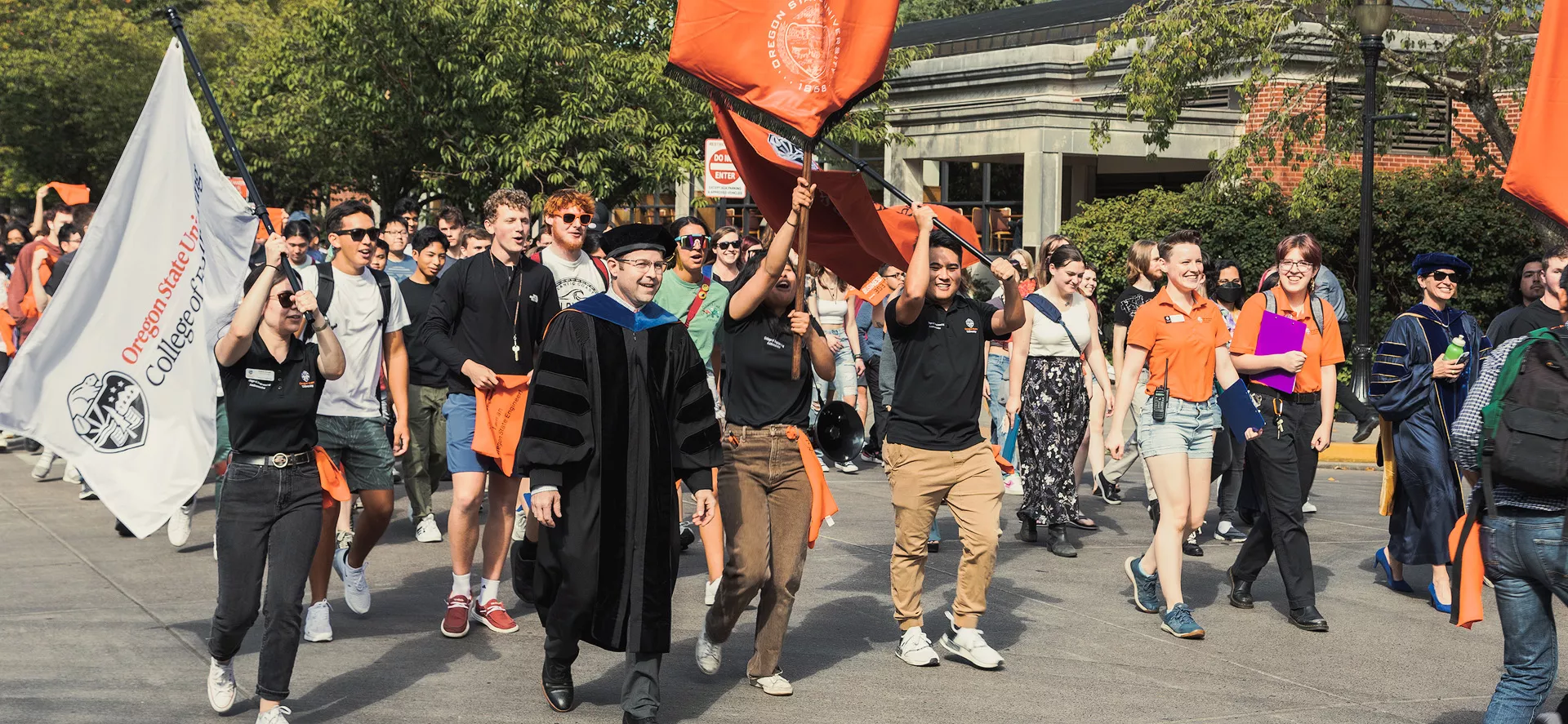 Students and staff walking in a graduation ceremony.