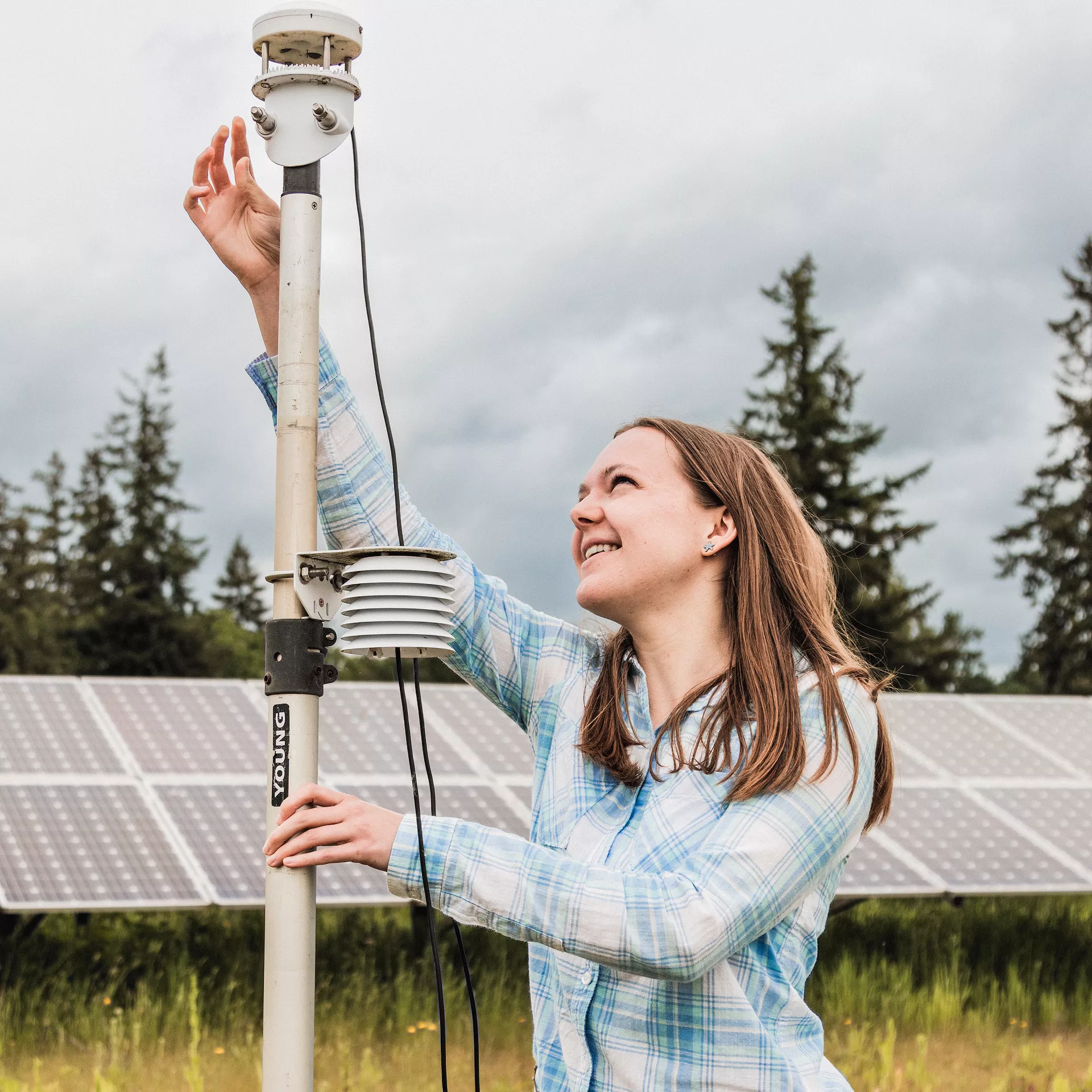 Student adjusts equipment outdoors.