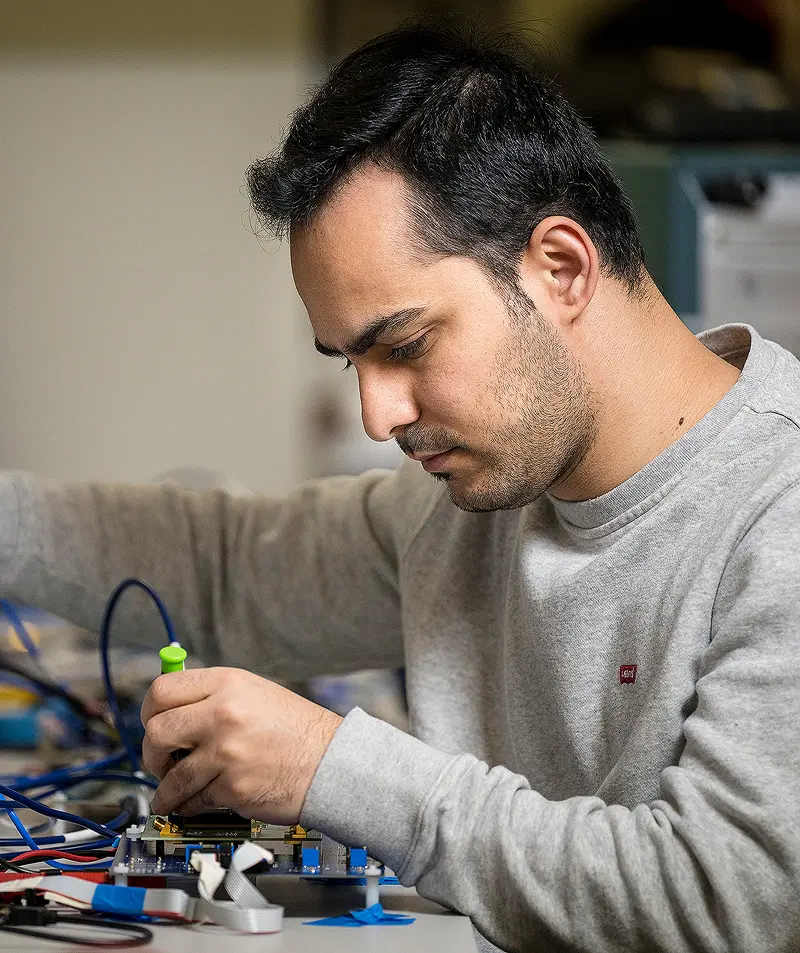 Student adjusting wires on a table