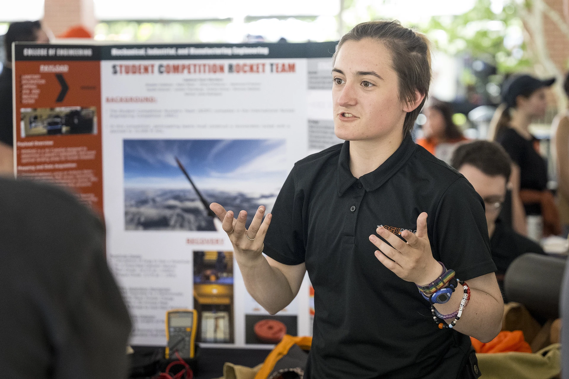 A student presenting his project at an expo event.
