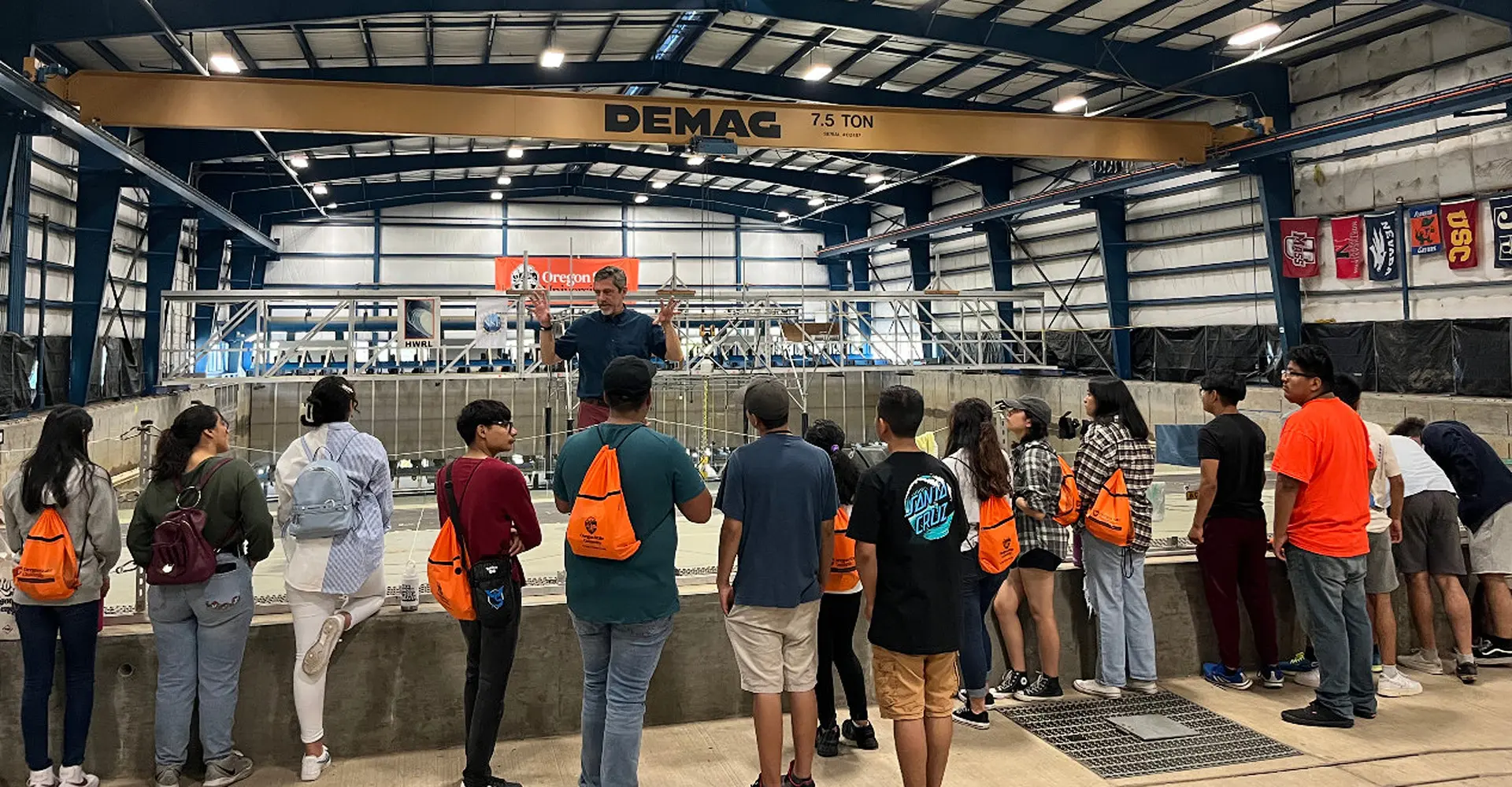 Students listening to a speaker presenting the wave lab.