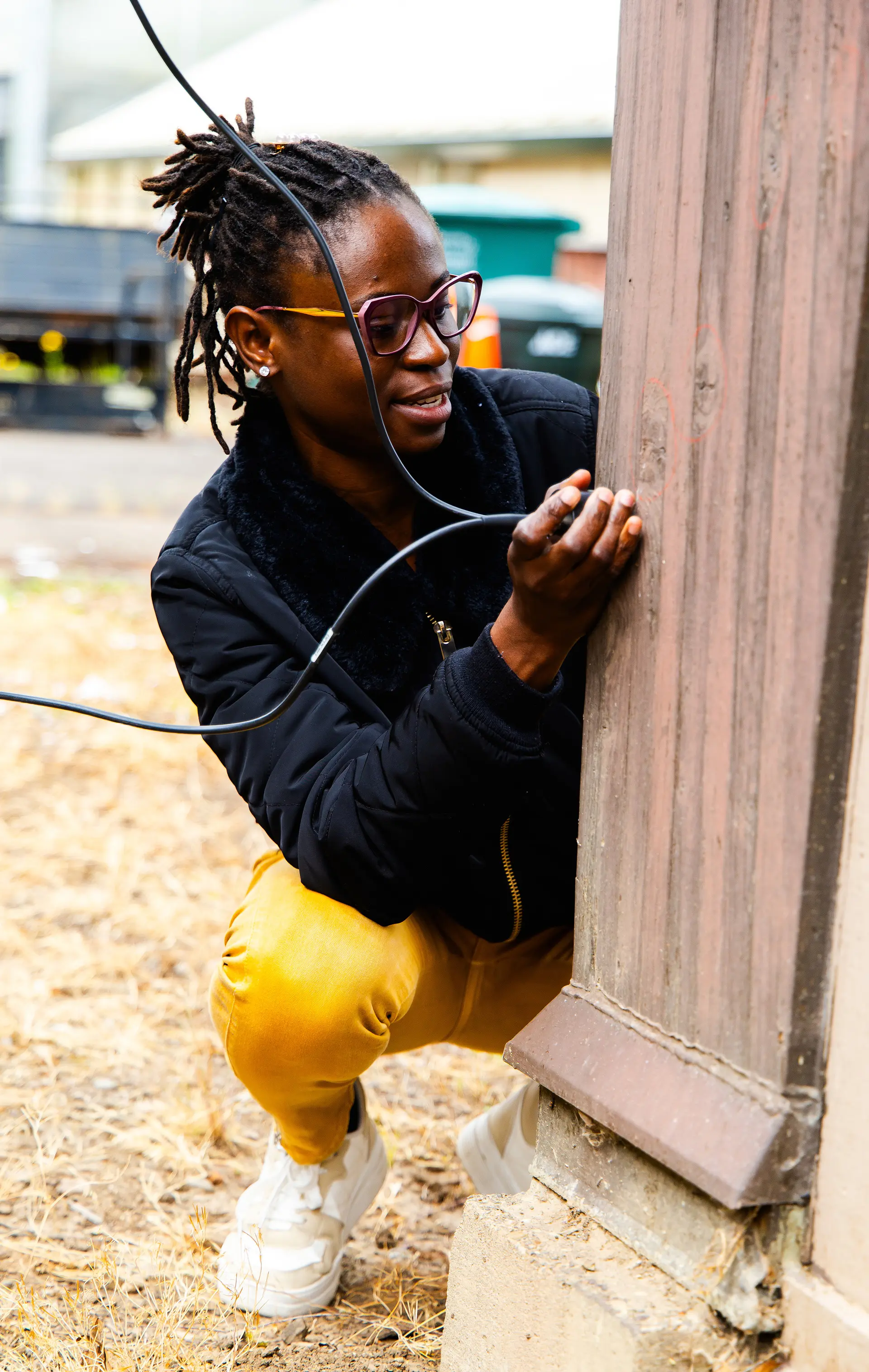 A student inspecting a wood structure.