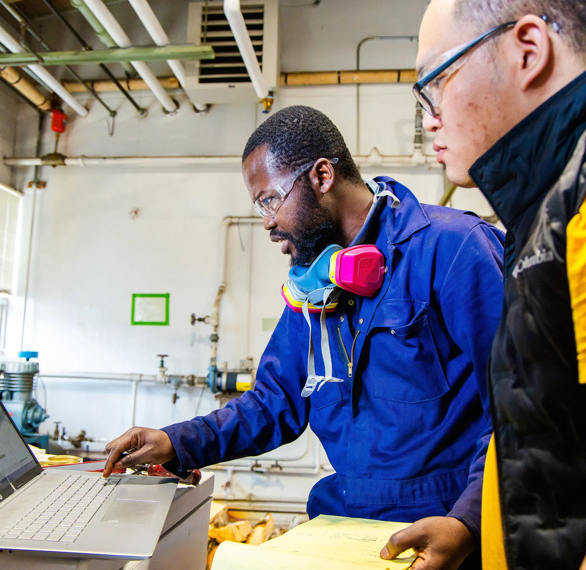 Two men looking at a laptop in a lab.