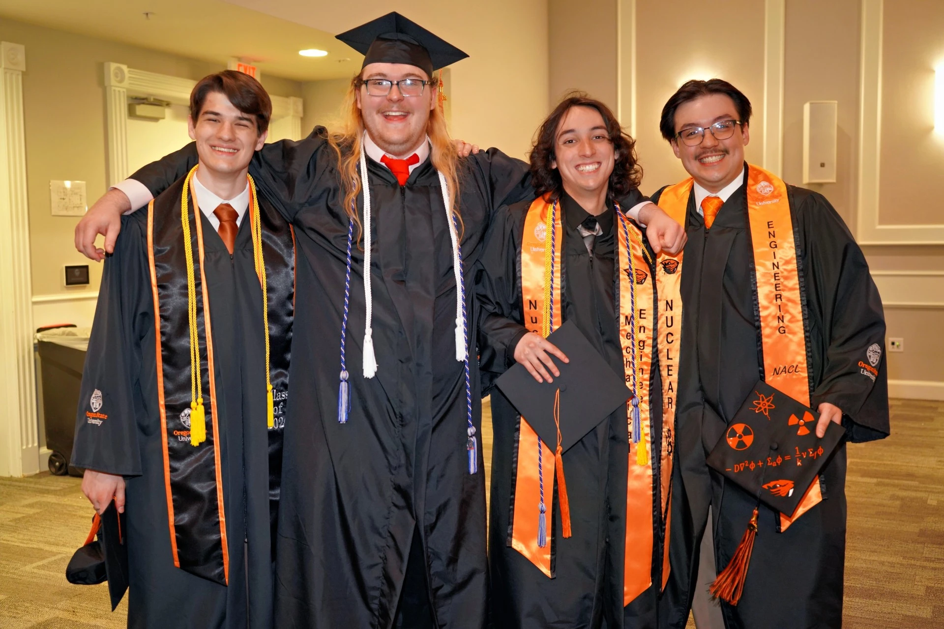 Oregon State University students wearing black caps and gowns attending graduation.