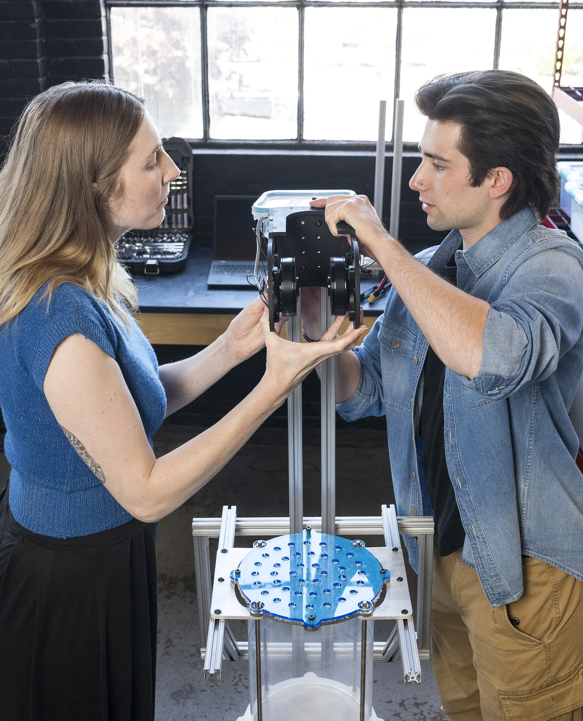 Two students holding a lab instrument.