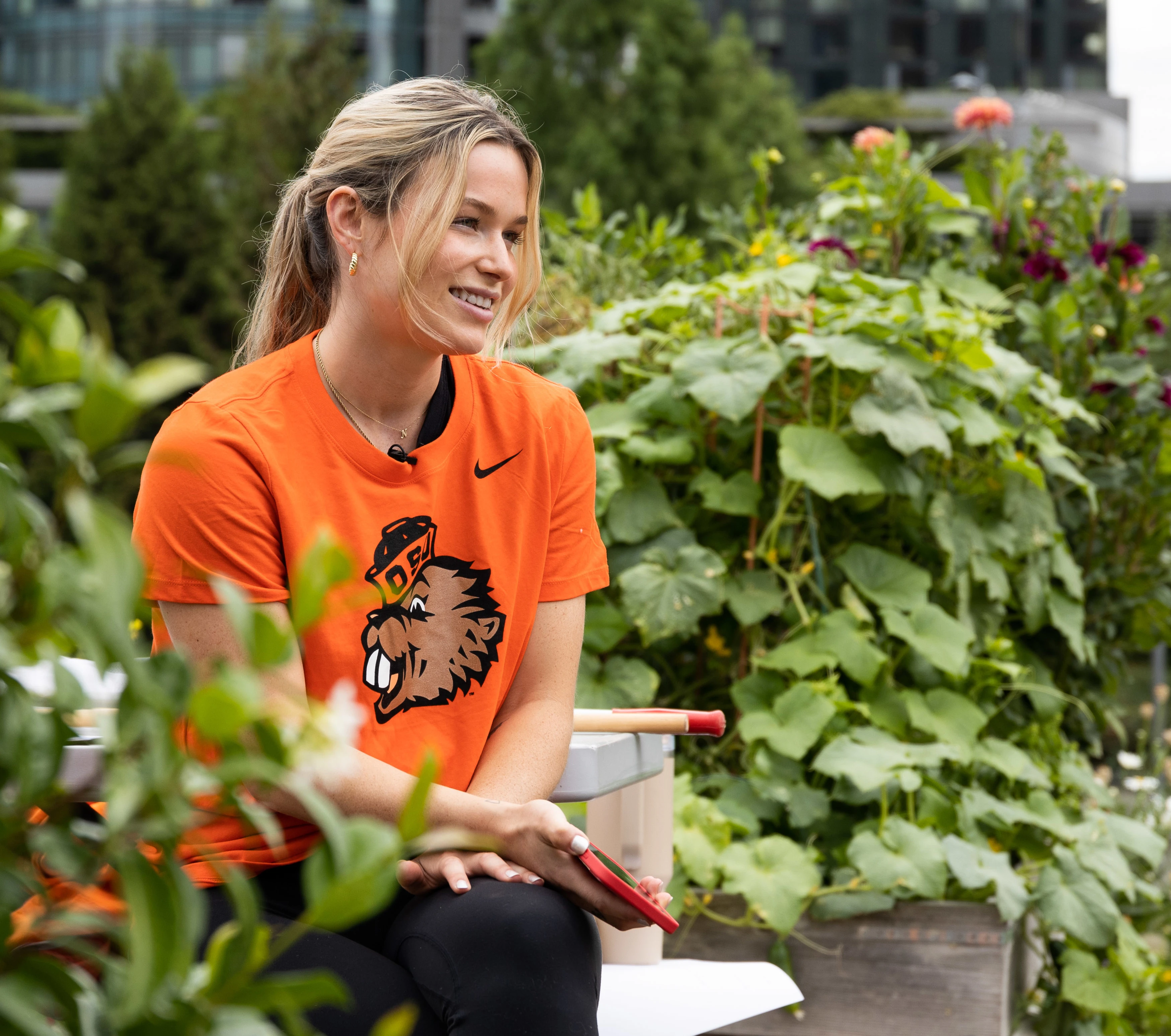 A student sitting on a bench around some plants.