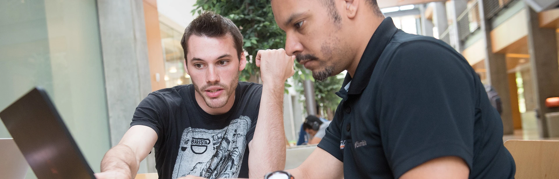 Peer tutor assisting a student at a table in Kelley Engineering Center.