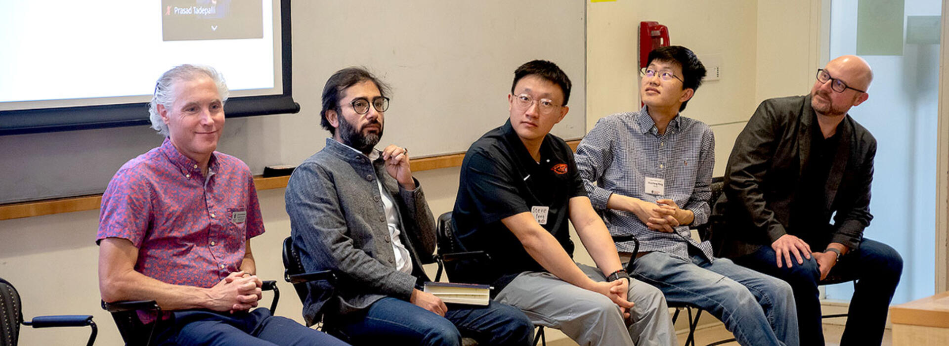 Chris Hundhausen, Houssam Abbas, Zixuan Feng, Huazheng Wang, and David Zier sitting with a presentation behind them.