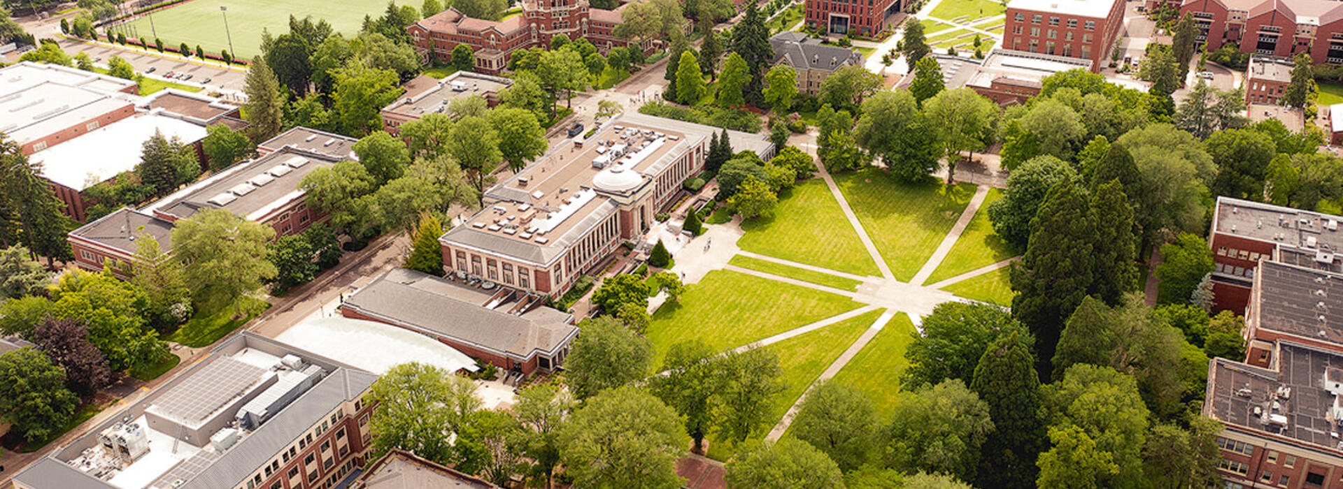 Oregon State University campus seen from above with green vegetation, buildings, and walking paths.