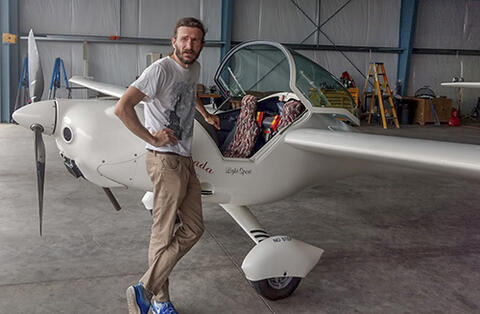 Justin Wolford in front of a small airplane.