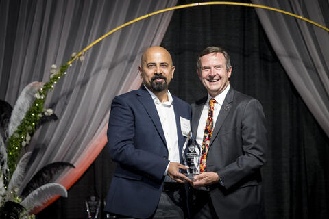 Robin Abraham receiving award from Scott Ashford.