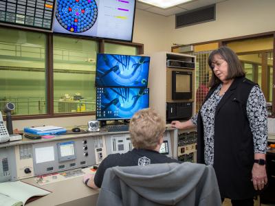 Two people talking at a control station.
