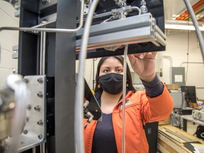 An engineering student working with a large machine.
