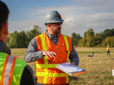 a person in a construction vest with a clip board