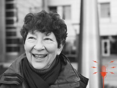 A woman smiling and looking at something.