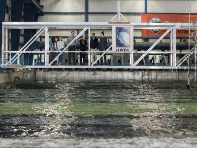 A group of people standing on a metal bridge.