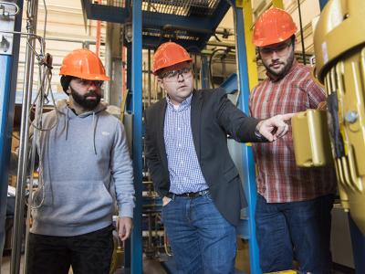 Nuclear Science examining a machine in facility.