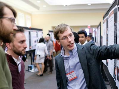 A picture of John Morrow presenting his research to a small audience.