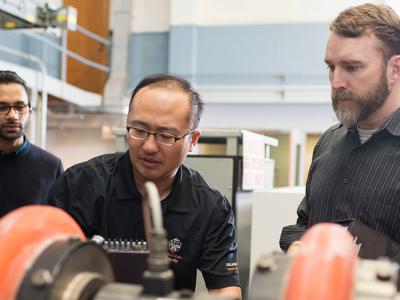 Three engineers working on machine