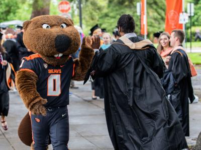 Benny Beaver high fives a graduate.