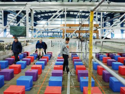 Three coastal and ocean engineering researchers walk in the wave lab.