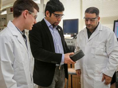 Faculty member Erdem Coleri and two students examine sample in lab.