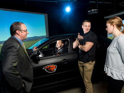 Faculty member David Hurwitz in the driving simulator with three graduate students.