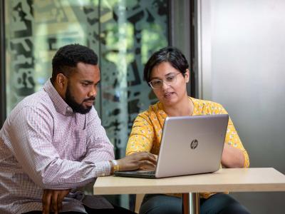 Two people looking at a laptop.