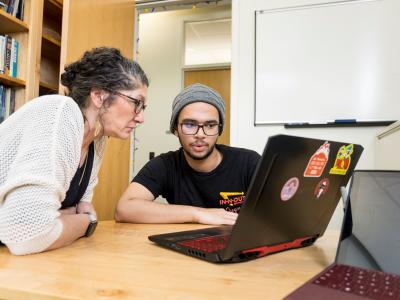 Faculty member Jennifer Parham-Mocello and student sit at laptop.